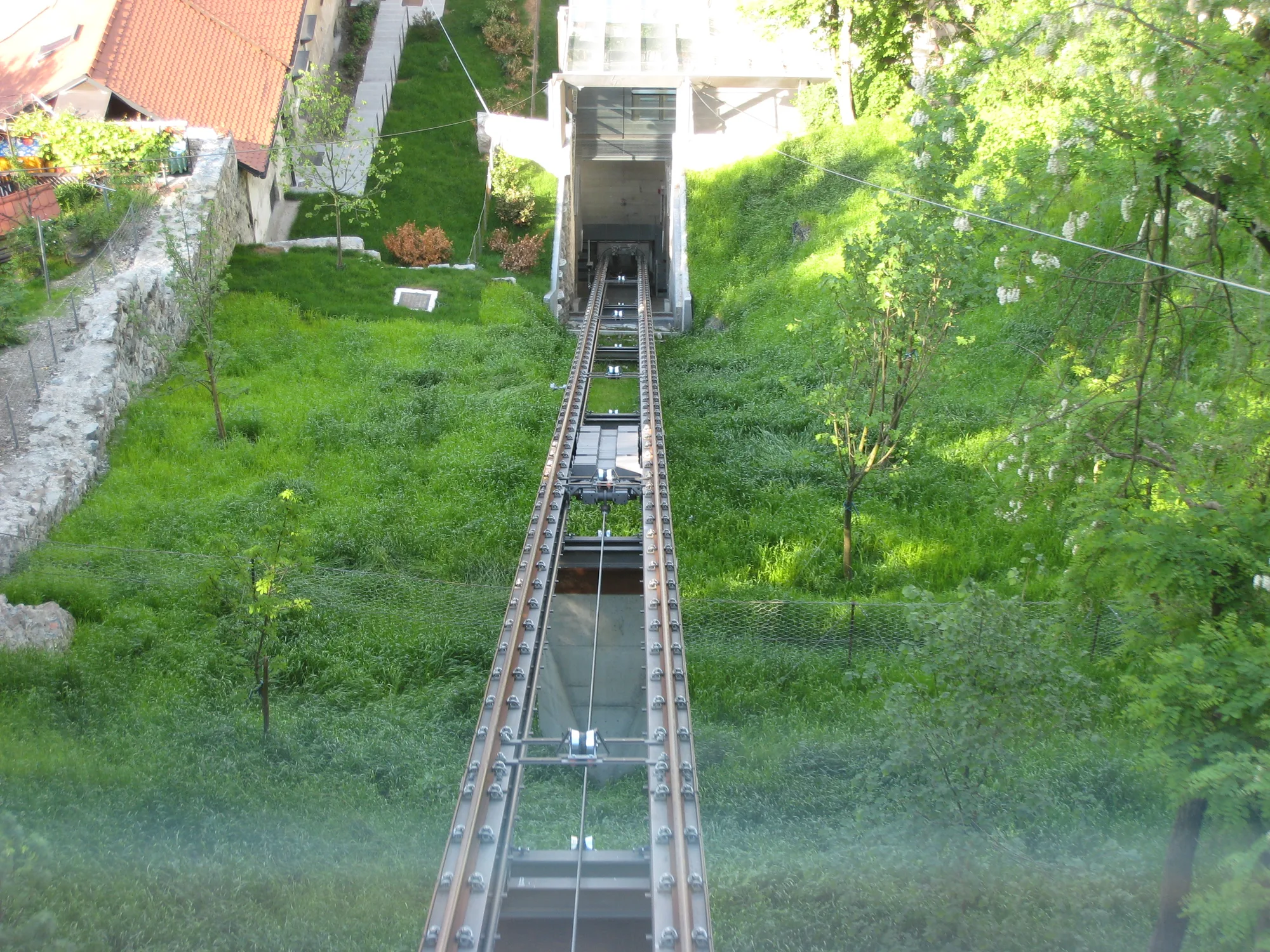 The glass funicular cabin climbing the wooded hill to Ljubljana Castle