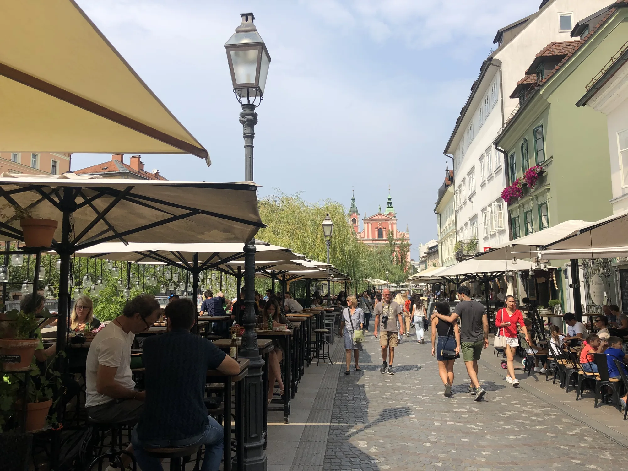 Café terraces and parasols crowding the Ljubljanica embankment on Cankarjevo nabrežje in central Ljubljana