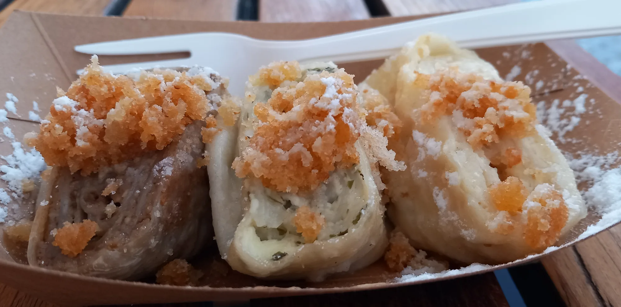 Sweet štruklji, the rolled Slovenian dumplings, sliced to show the spiral and dusted with breadcrumbs